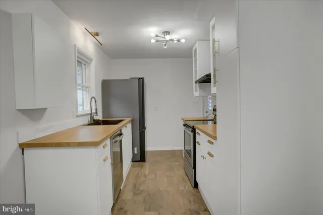 a kitchen with a sink a stove and cabinets