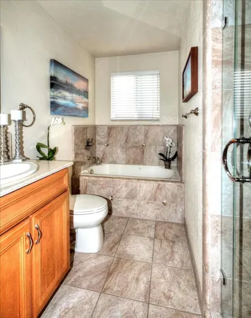 a bathroom with a granite countertop sink mirror vanity and toilet