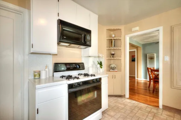 a kitchen with microwave a stove and a refrigerator