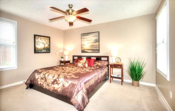 a bedroom with a large bed and a chandelier