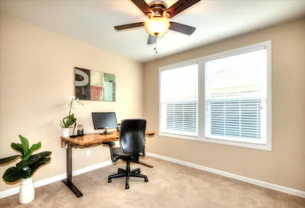 a view of a workspace with furniture and a window