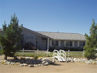 9030 Verbena Road Oak Hills, CA 92344 - Photo 1 of 1 a front view of a house with a yard and garage