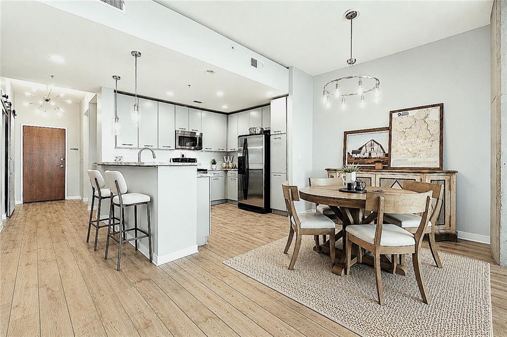 3300 Windy Ridge Parkway Southeast, Unit 1112 Atlanta, GA 30339 - Photo 10 of 43 a kitchen with stainless steel appliances kitchen island granite countertop a table chairs and a refrigerator