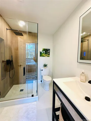 a bathroom with a granite countertop sink a toilet and shower