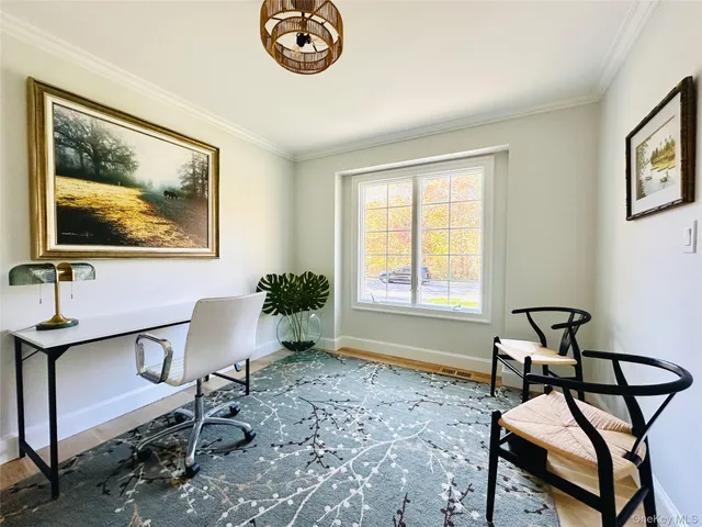 a view of a workspace with furniture and a window