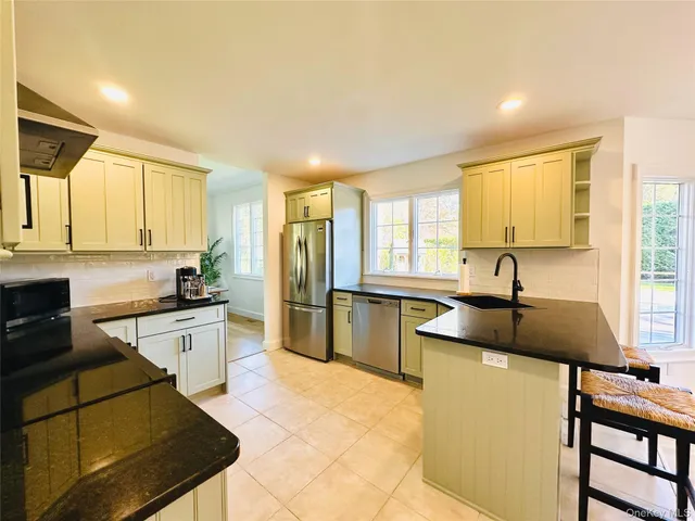 a large kitchen with granite countertop a sink and a stove top oven