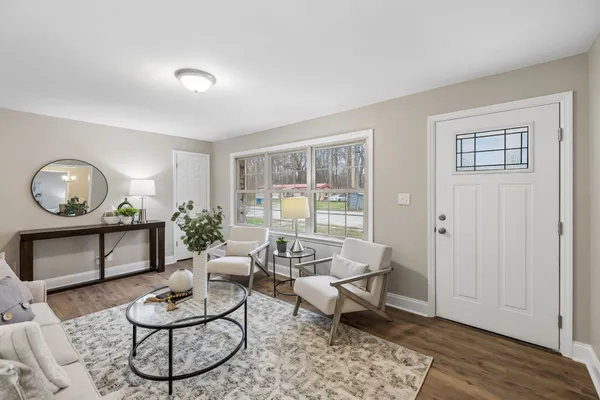 a living room with furniture a rug and a window