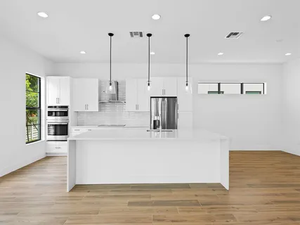 a view of a kitchen with kitchen island a counter top space appliances and cabinets