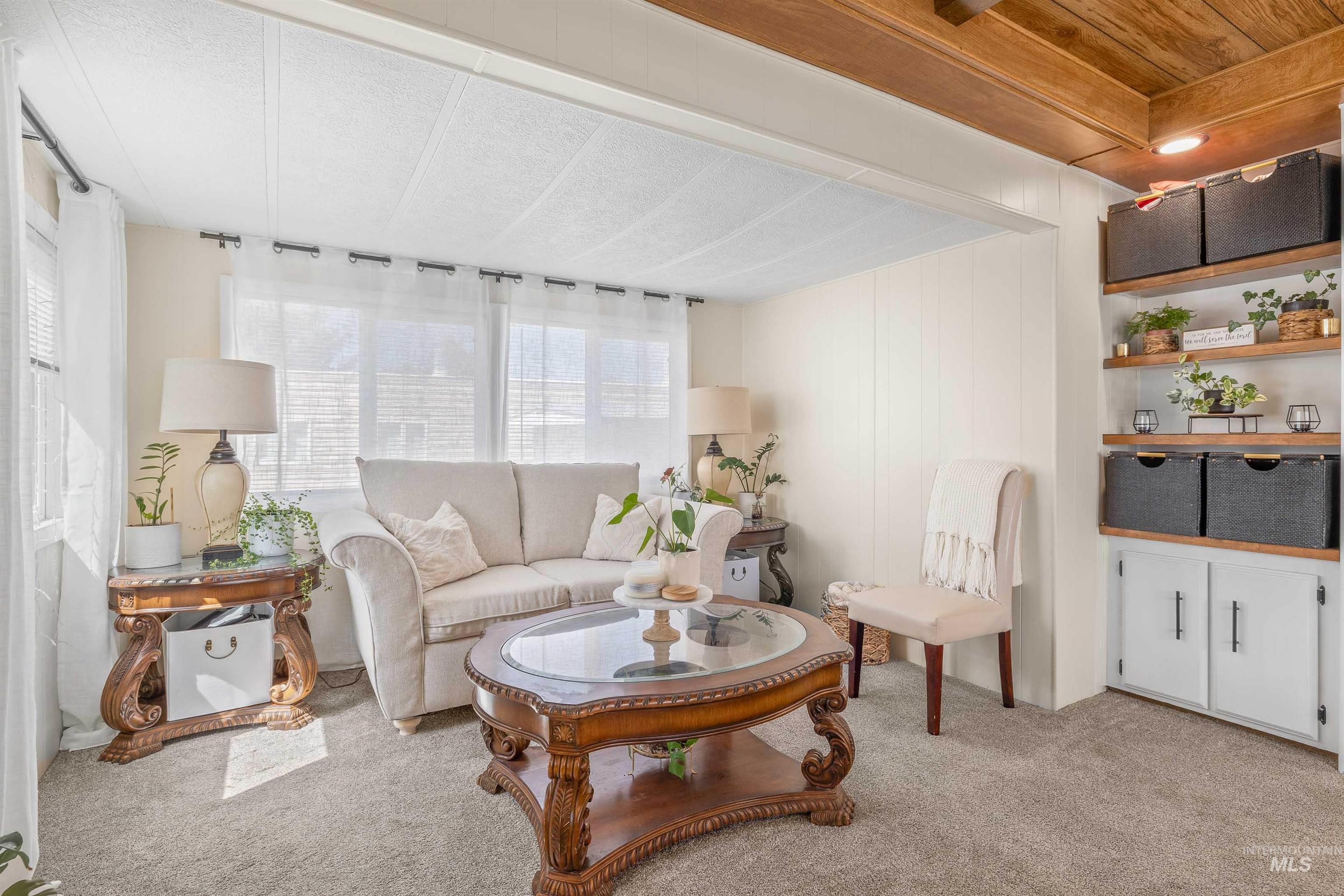 198 South Hills Road, Unit 115 Twin Falls, ID 83301 - Photo 1 of 22 Living area with light colored carpet and wooden ceiling