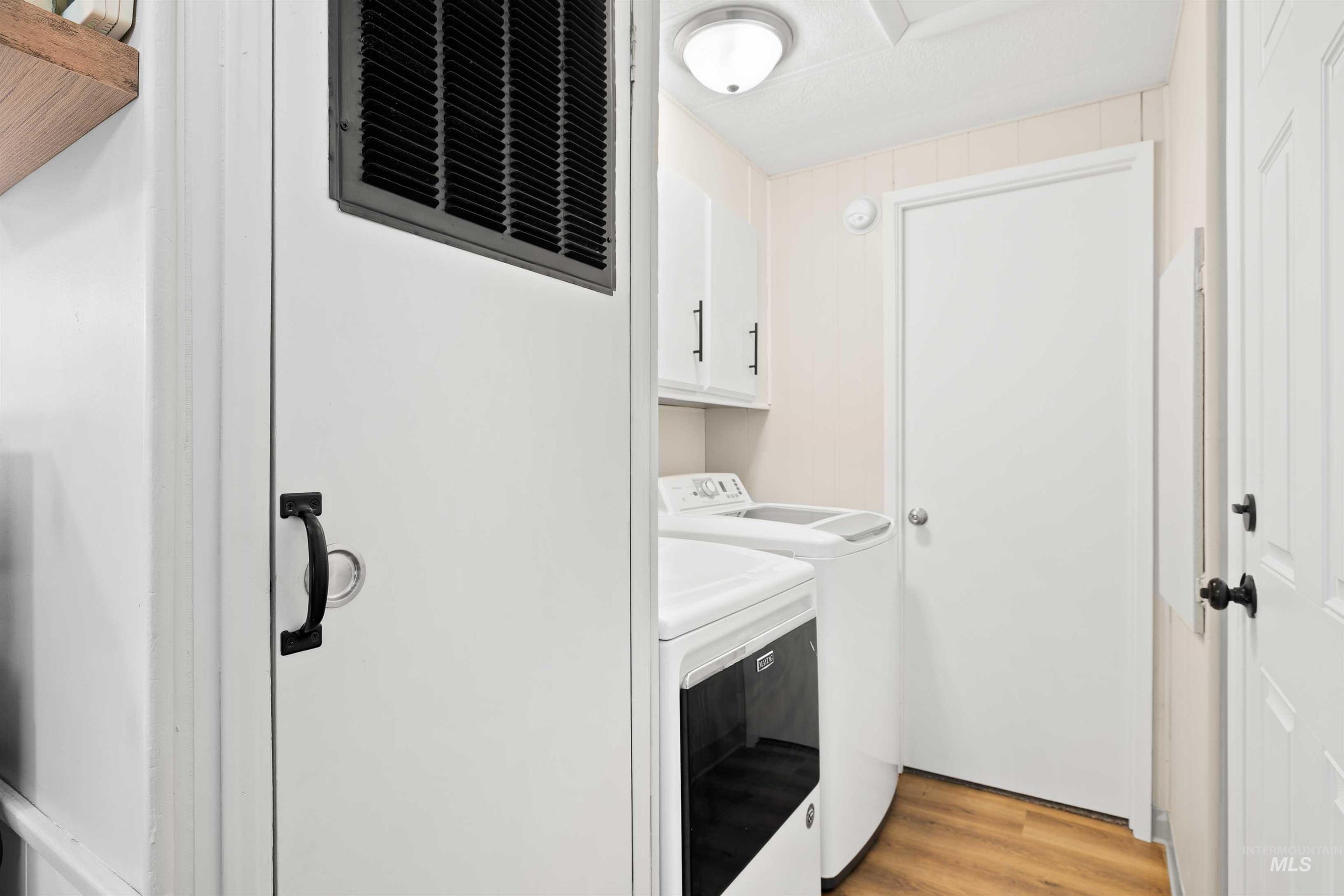 198 South Hills Road, Unit 115 Twin Falls, ID 83301 - Photo 16 of 22 Washroom with light wood-style flooring, separate washer and dryer, and cabinet space