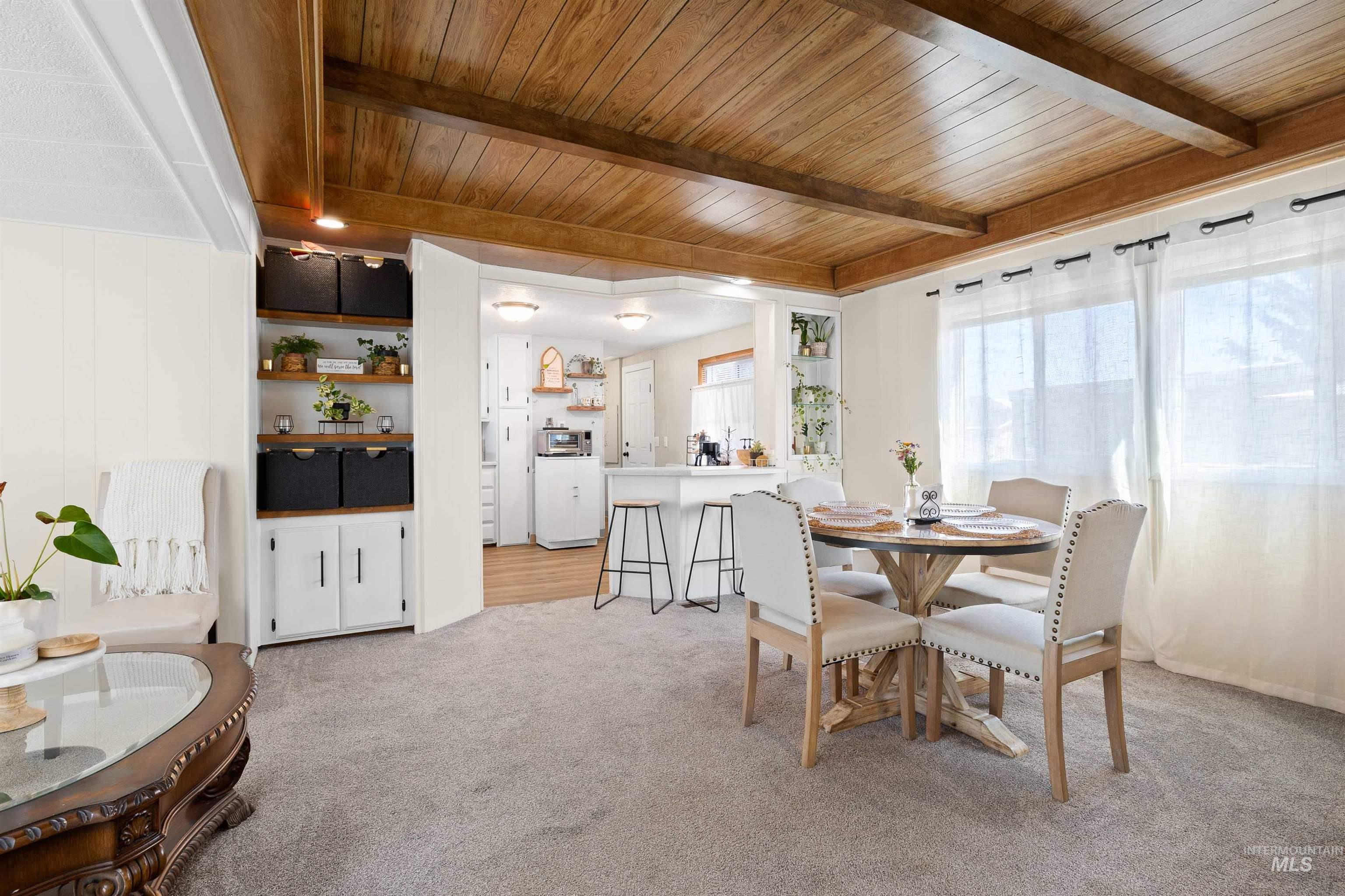 198 South Hills Road, Unit 115 Twin Falls, ID 83301 - Photo 2 of 22 Dining room with light colored carpet and a wooden ceiling with exposed beams