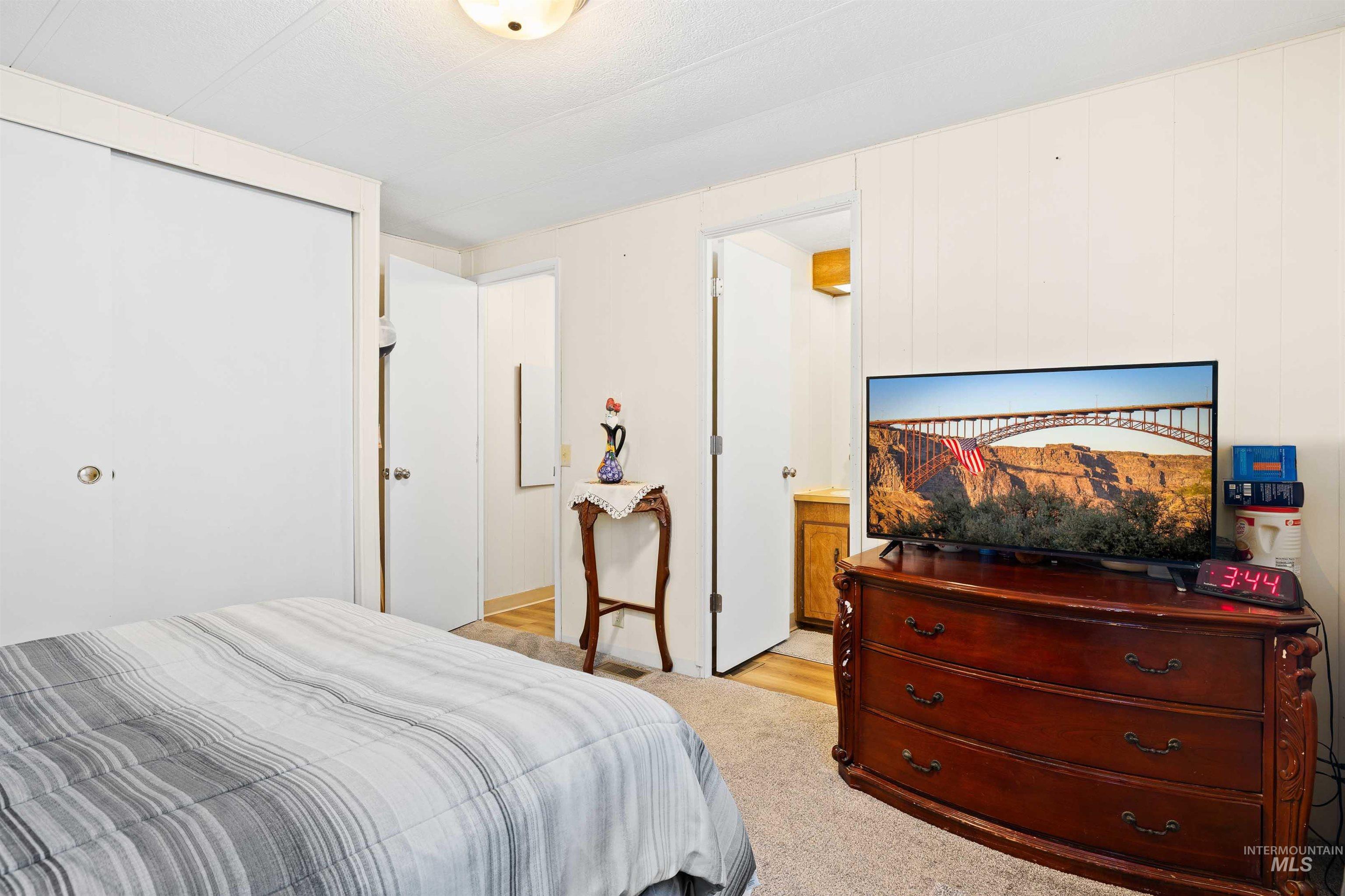 198 South Hills Road, Unit 115 Twin Falls, ID 83301 - Photo 9 of 22 Bedroom with light colored carpet and ensuite bath