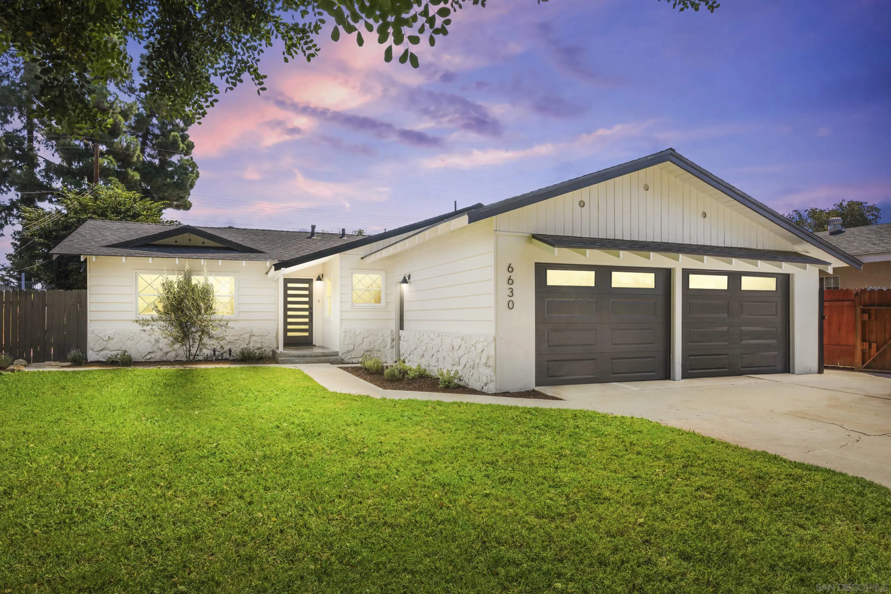 a front view of a house with yard and garage