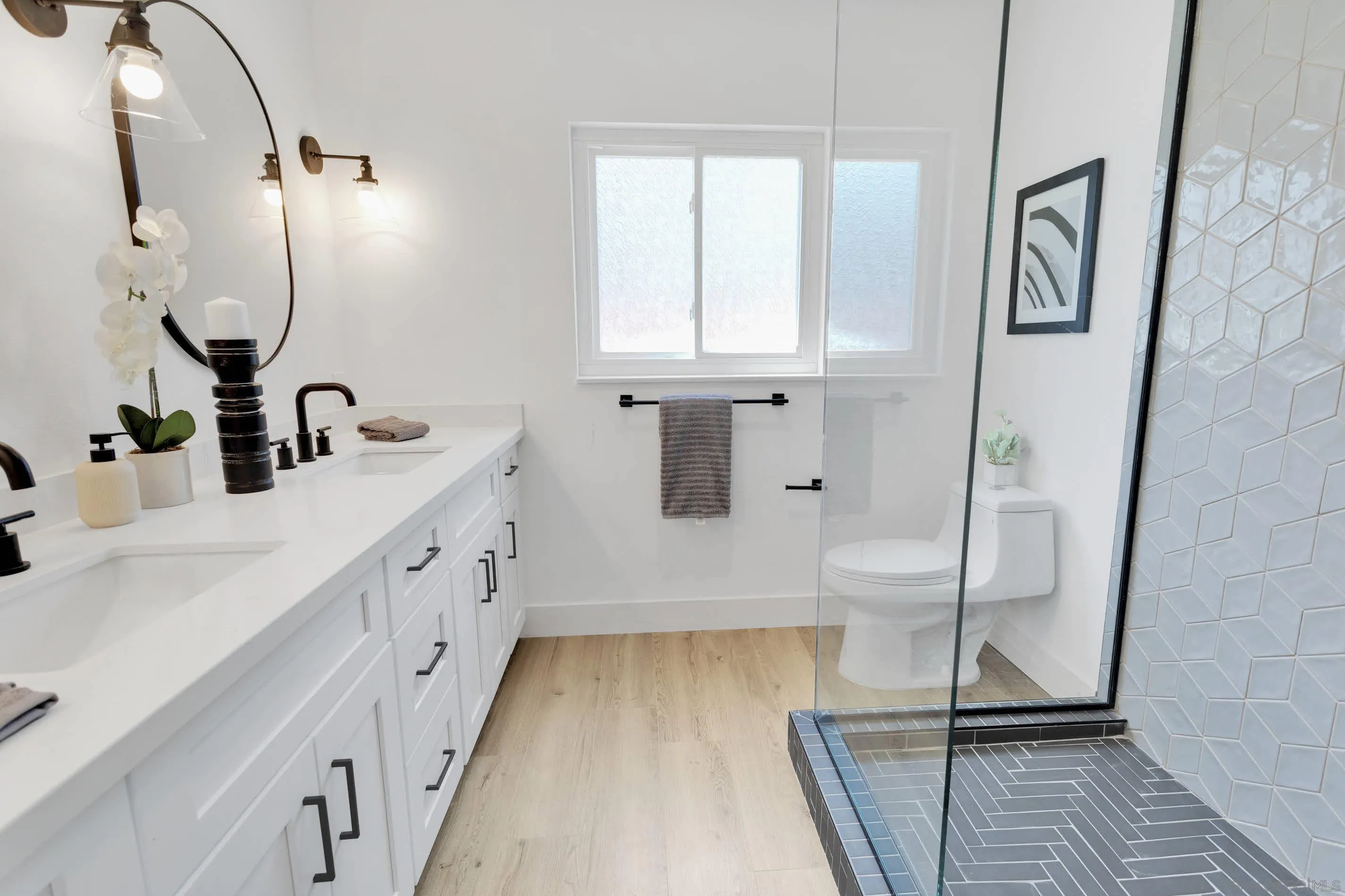 6630 Montclair Drive Riverside, CA 92504 - Photo 29 of 47 a bathroom with a double vanity sink a mirror and a shower