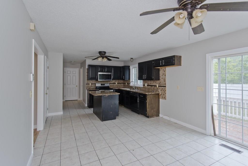 23 Martha Street Springfield, MA 01151 - Photo 5 of 19 a kitchen with stainless steel appliances kitchen island granite countertop a refrigerator a sink a stove top oven a counter space and cabinets