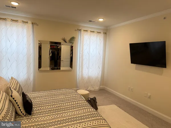 a view of a livingroom with wooden floor and a flat screen tv