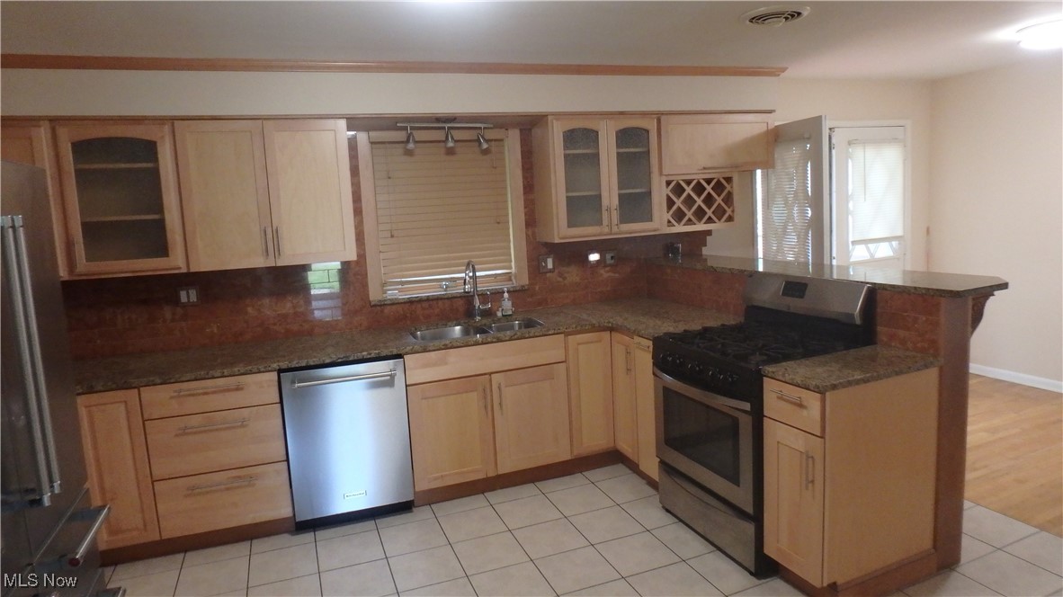 2901 Dentzler Road Parma, OH 44134 - Photo 10 of 25 Kitchen with stainless steel appliances, light brown cabinetry, and a peninsula