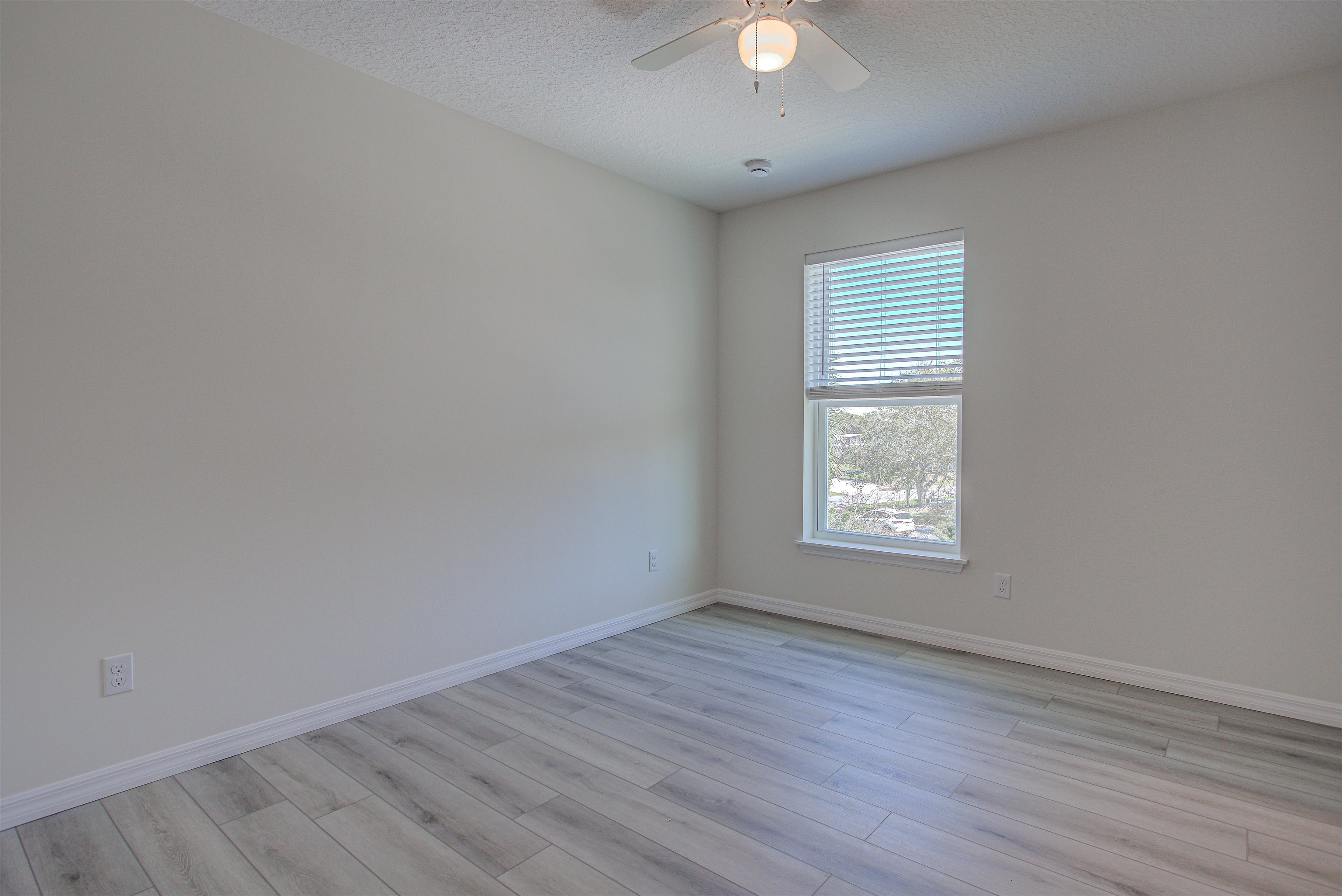 253 Desoto Road St. Augustine, FL 32080 - Photo 11 of 25 Empty room featuring a textured ceiling, light wood-type flooring, and a ceiling fan