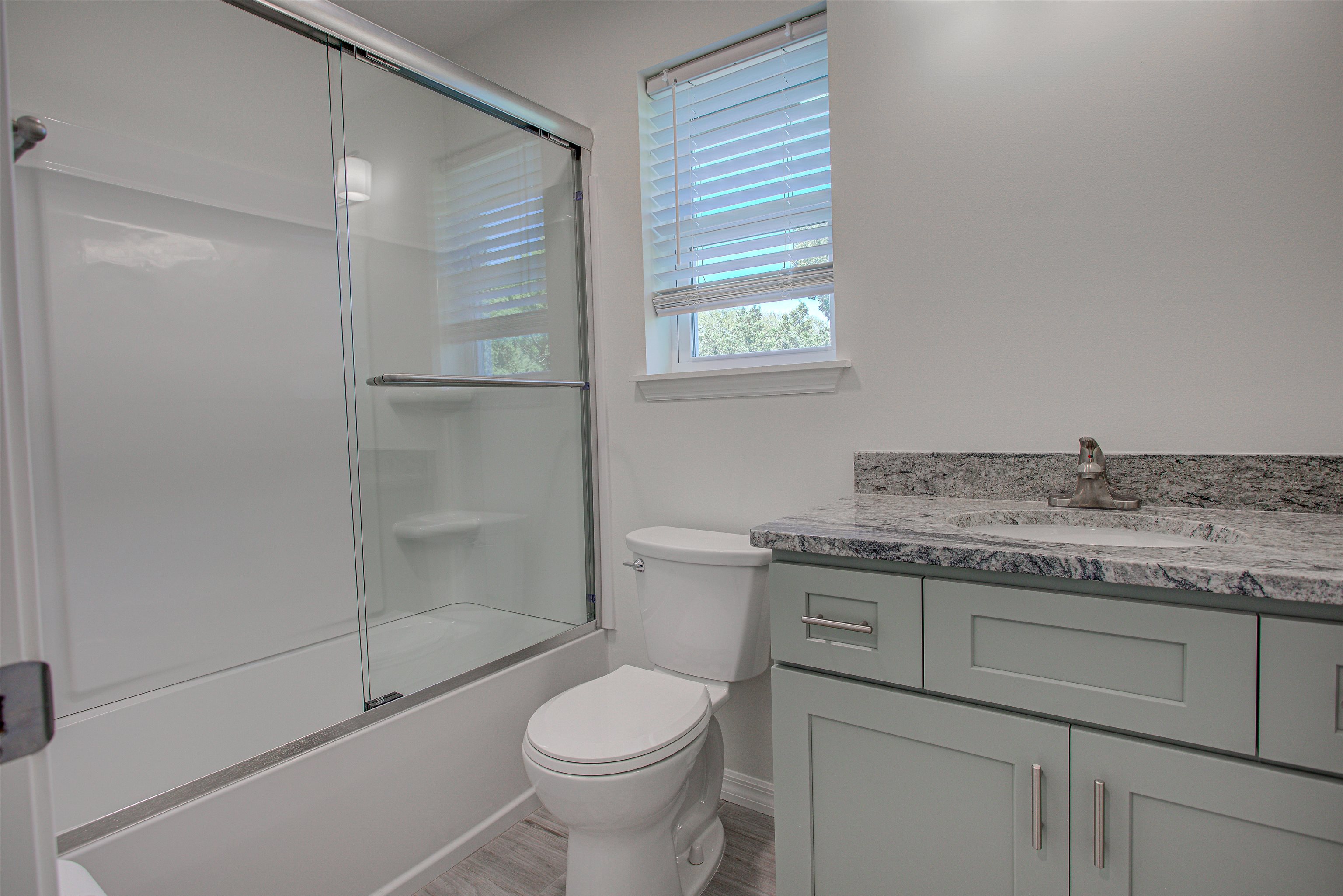 253 Desoto Road St. Augustine, FL 32080 - Photo 13 of 25 Bathroom featuring vanity, shower / bath combination with glass door, and wood finished floors