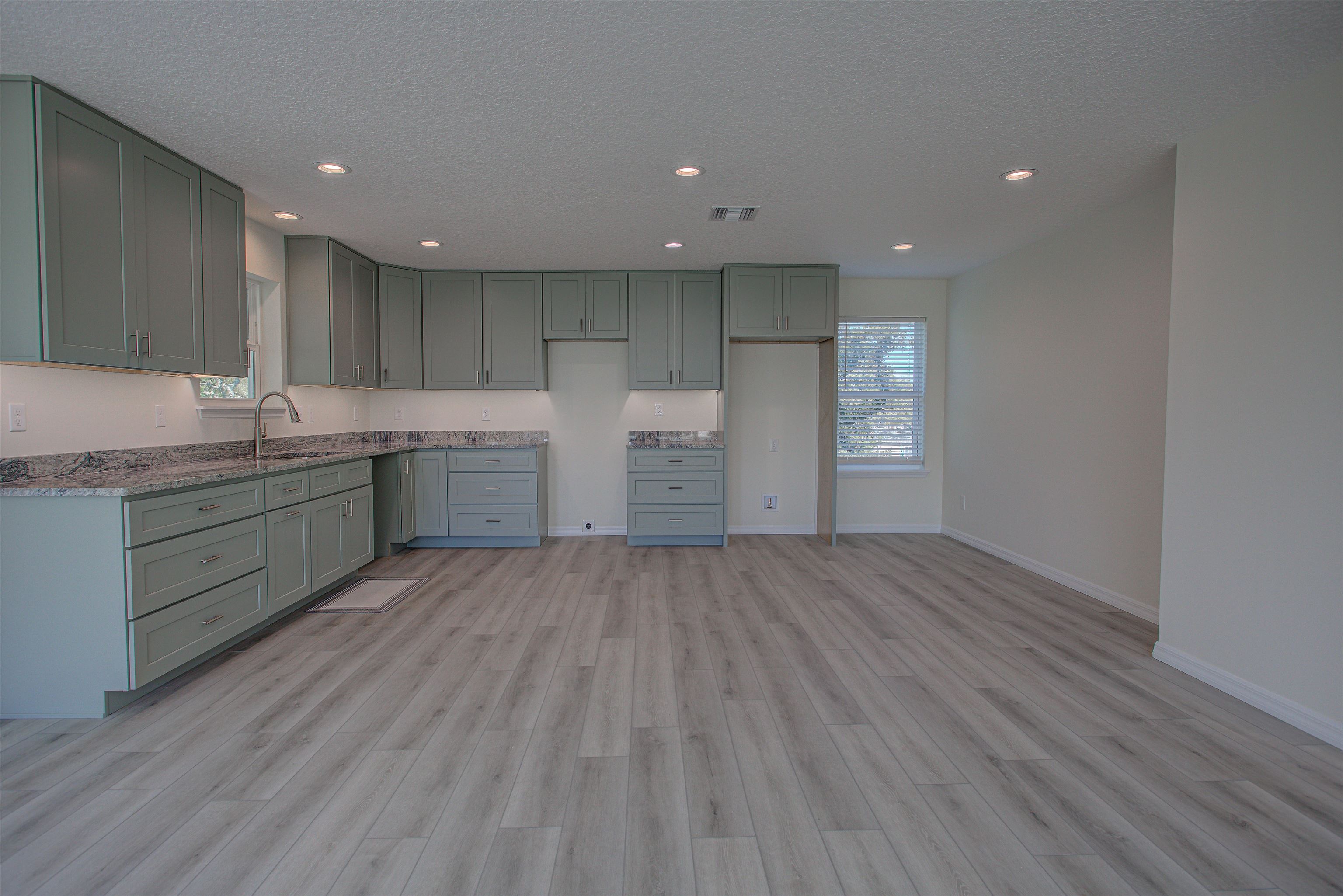 253 Desoto Road St. Augustine, FL 32080 - Photo 4 of 25 Kitchen featuring recessed lighting, light wood-style floors, light stone countertops, and a textured ceiling