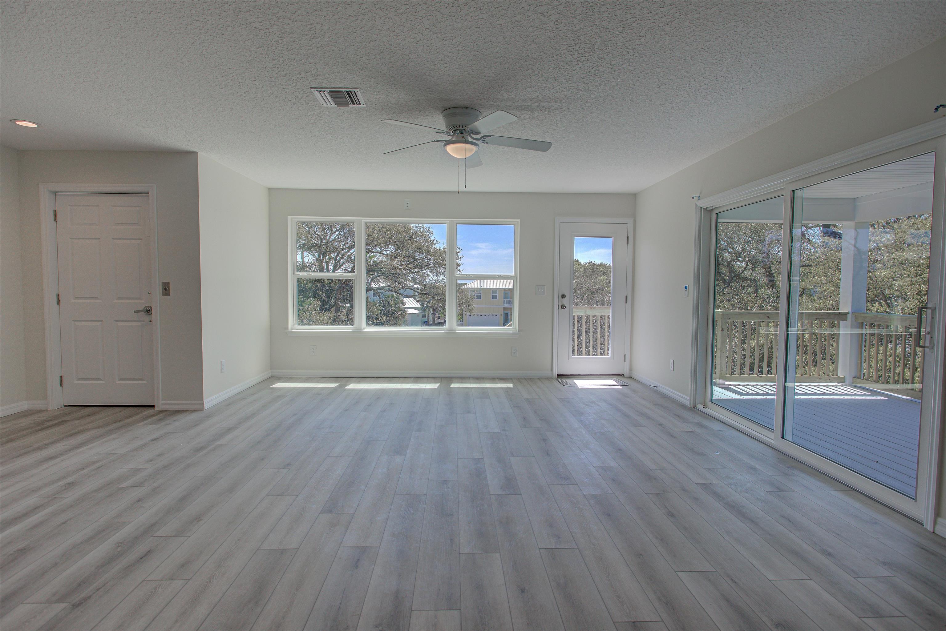 253 Desoto Road St. Augustine, FL 32080 - Photo 6 of 25 Unfurnished living room featuring a ceiling fan, light wood-style floors, and a textured ceiling