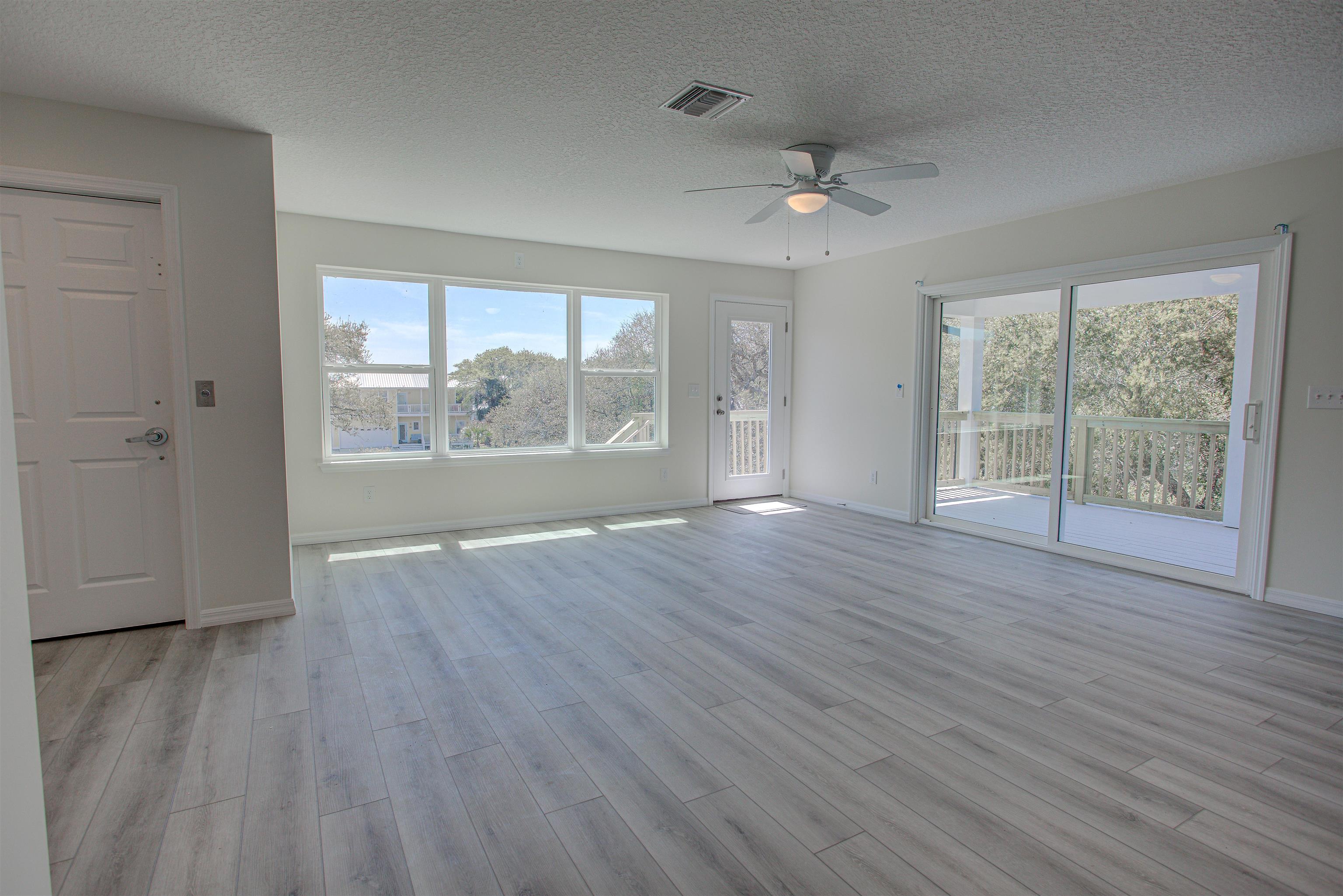 253 Desoto Road St. Augustine, FL 32080 - Photo 7 of 25 Unfurnished living room featuring a textured ceiling, a ceiling fan, and light wood-type flooring