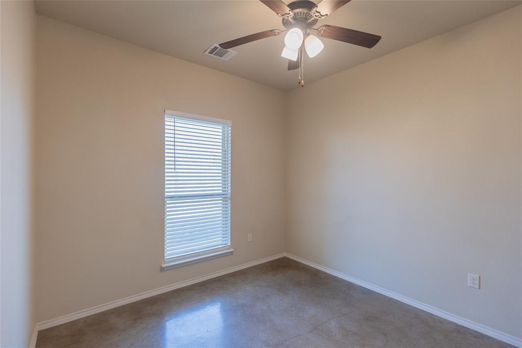 351 Joanne Loop, Unit A Buda, TX 78610 - Photo 12 of 17 A well-lit bedroom featuring a functional ceiling fan and durable concrete flooring.