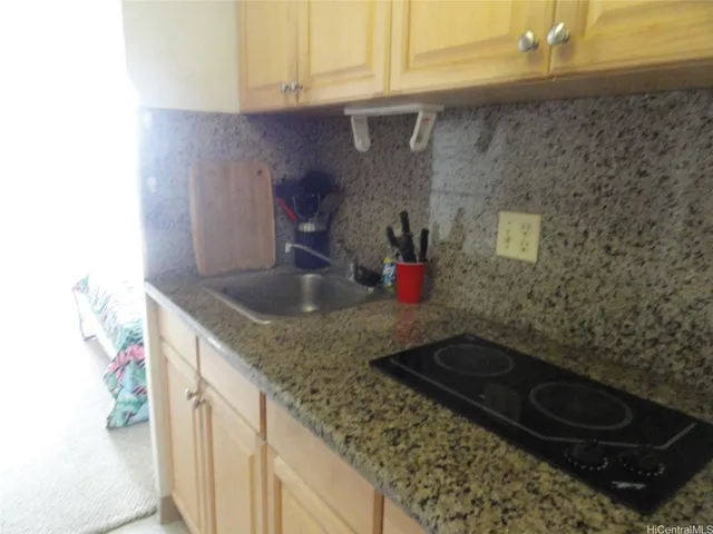 a kitchen with granite countertop a sink and a stove