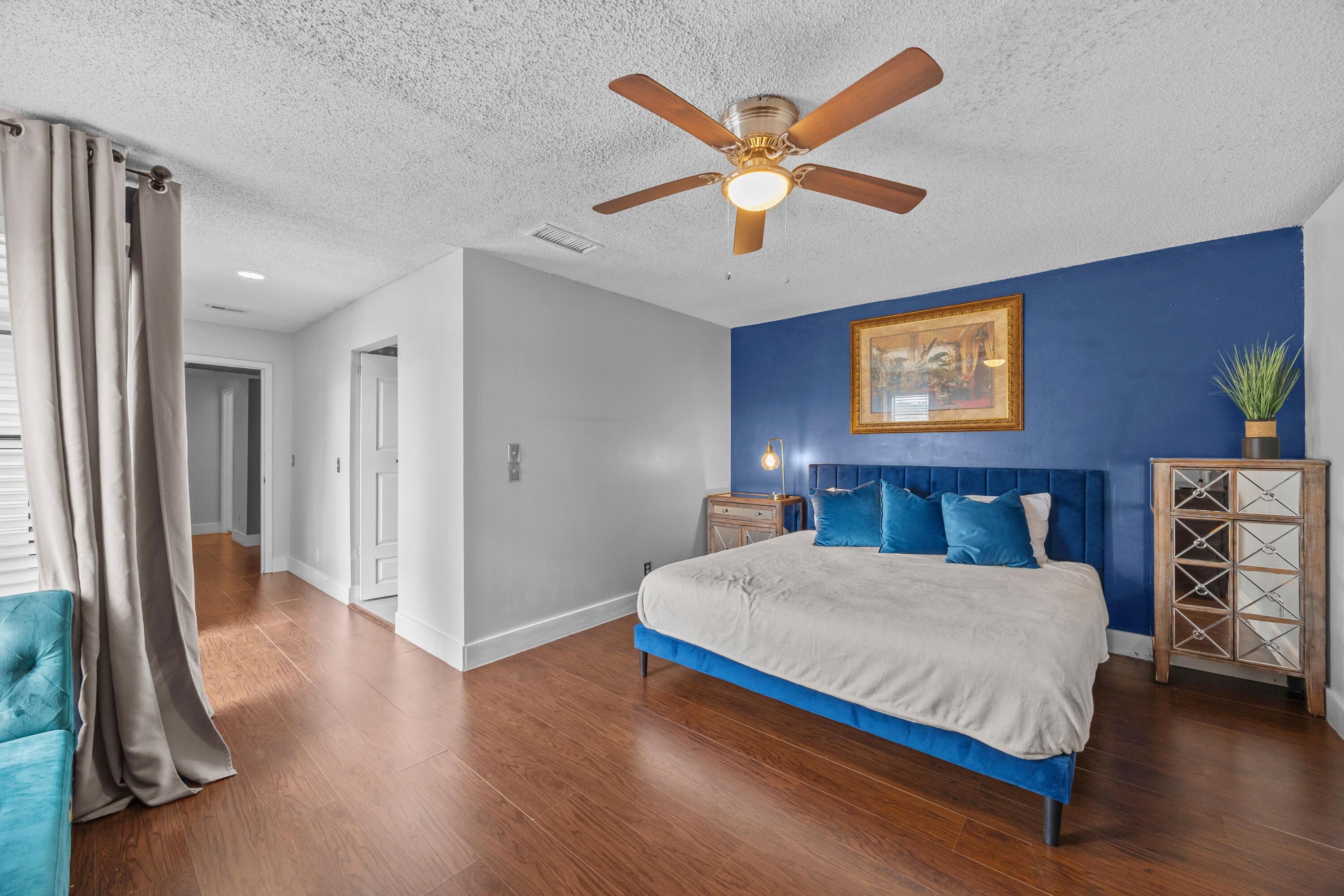 1520 Shaker Circle Wellington, FL 33414 - Photo 11 of 19 a bedroom with a large bed and a chandelier