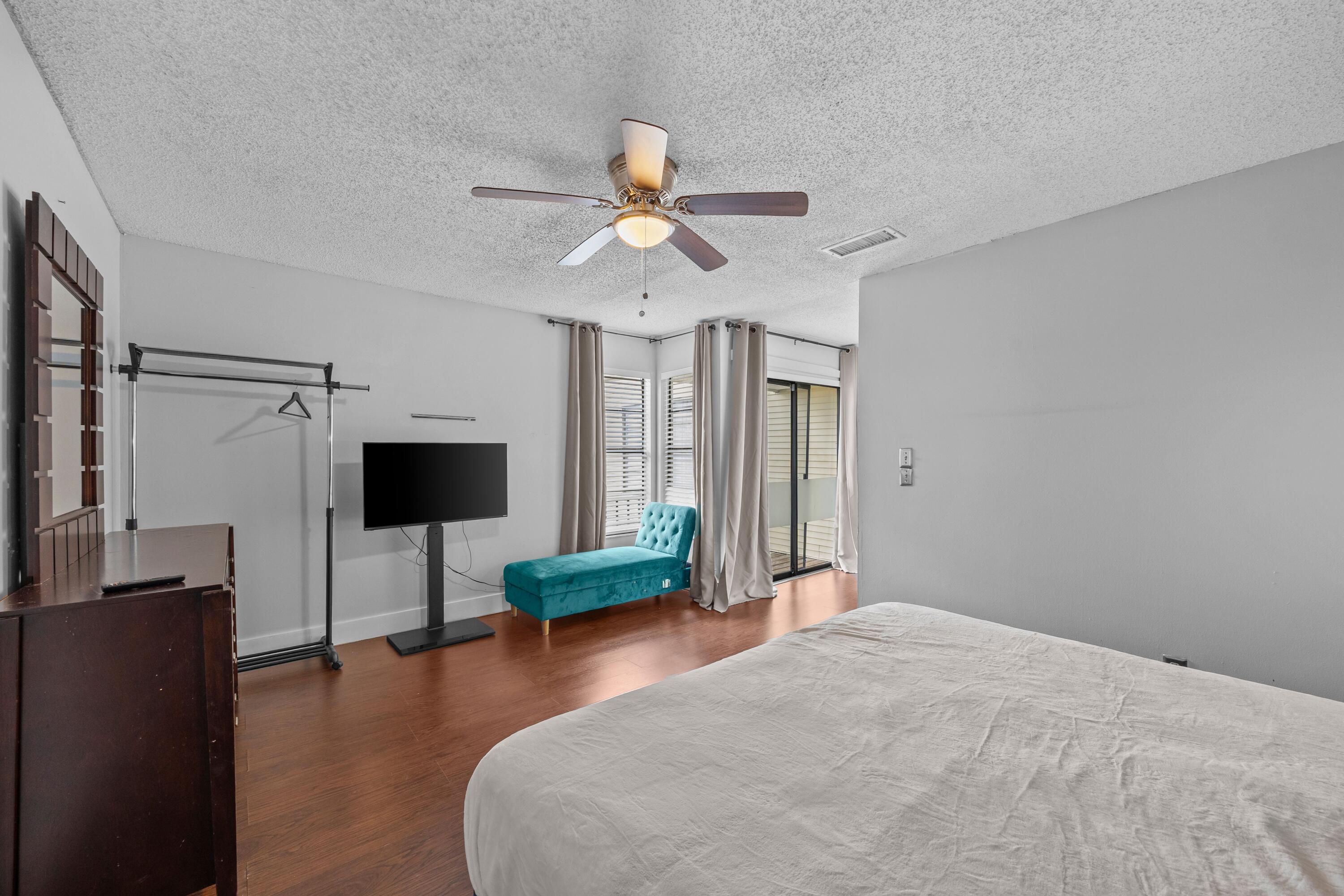 1520 Shaker Circle Wellington, FL 33414 - Photo 12 of 19 a bedroom with a bed and a chandelier