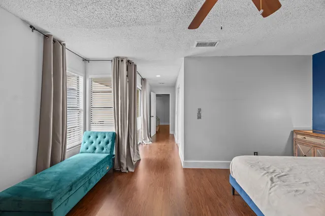 a hallway with a bed and wooden floor