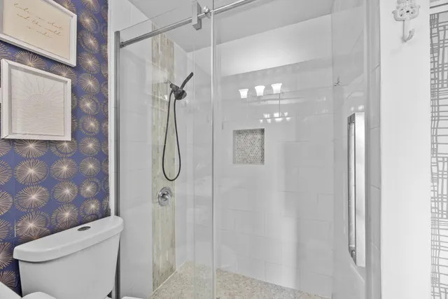 a bathroom with a shower a toilet and sink