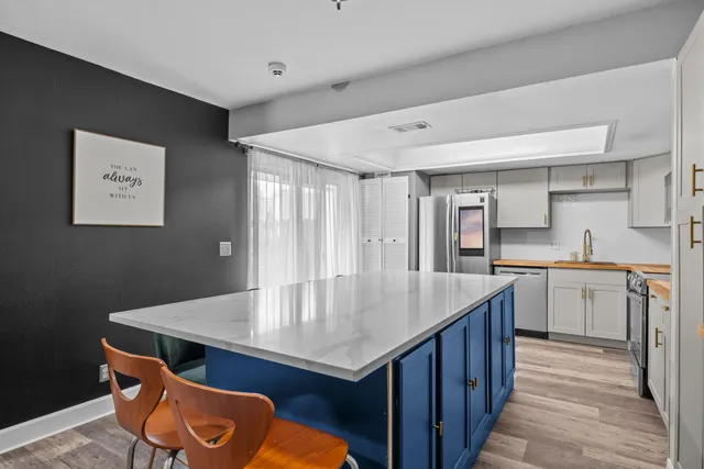 a kitchen with a sink a cabinets and wooden floor