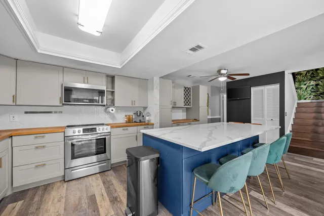 a kitchen with a stove a sink dishwasher a refrigerator with a dining table and chairs