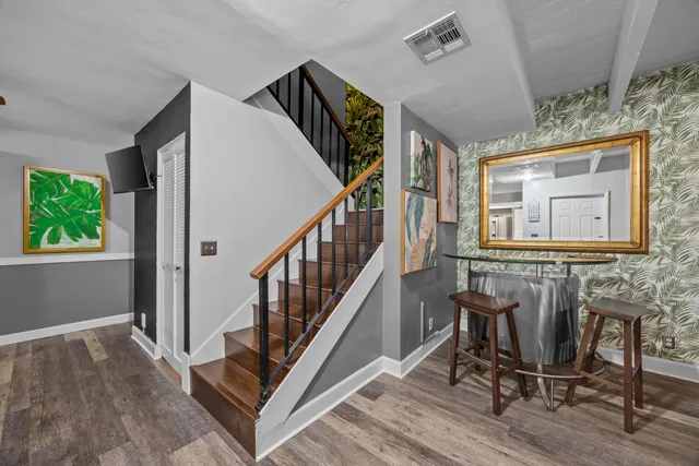 a view of a hallway with wooden floor and windows
