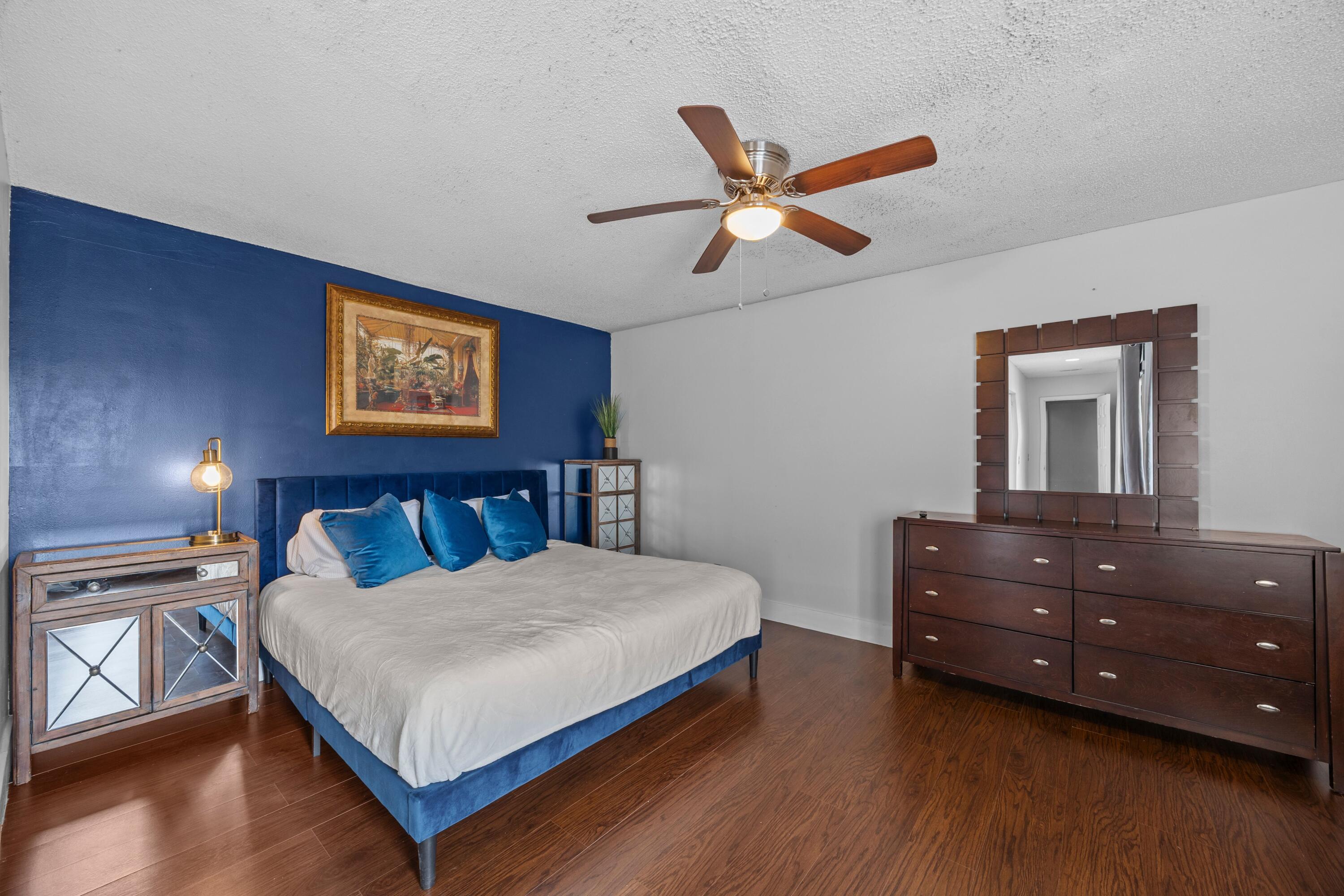 1520 Shaker Circle Wellington, FL 33414 - Photo 10 of 19 a bedroom with a bed and a chandelier