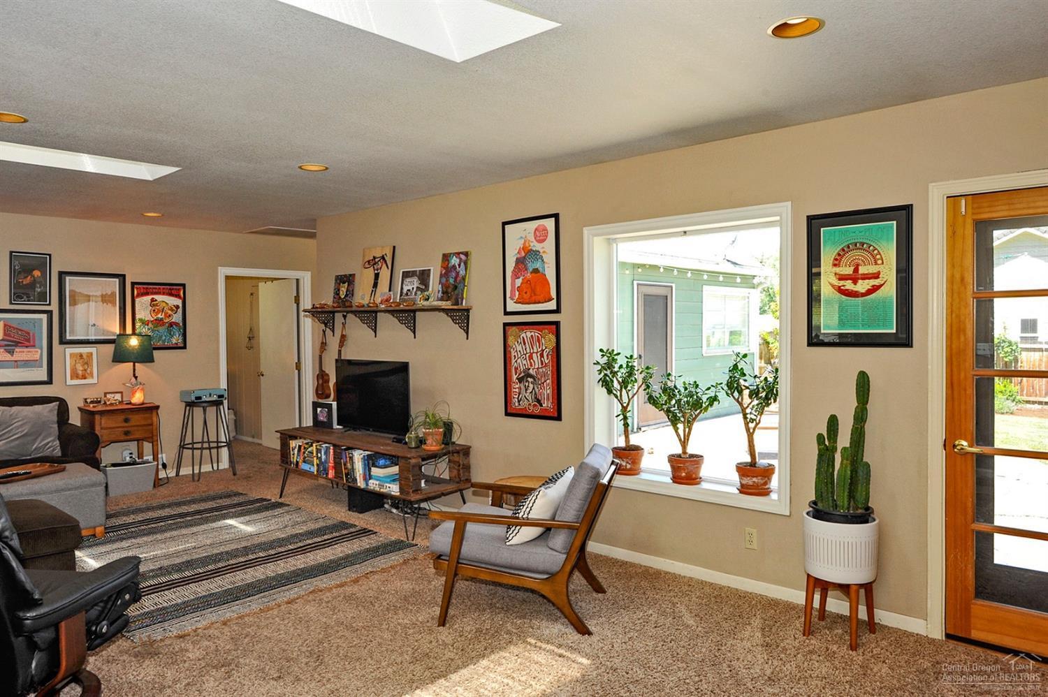 Living room offers skylights, picture wi
