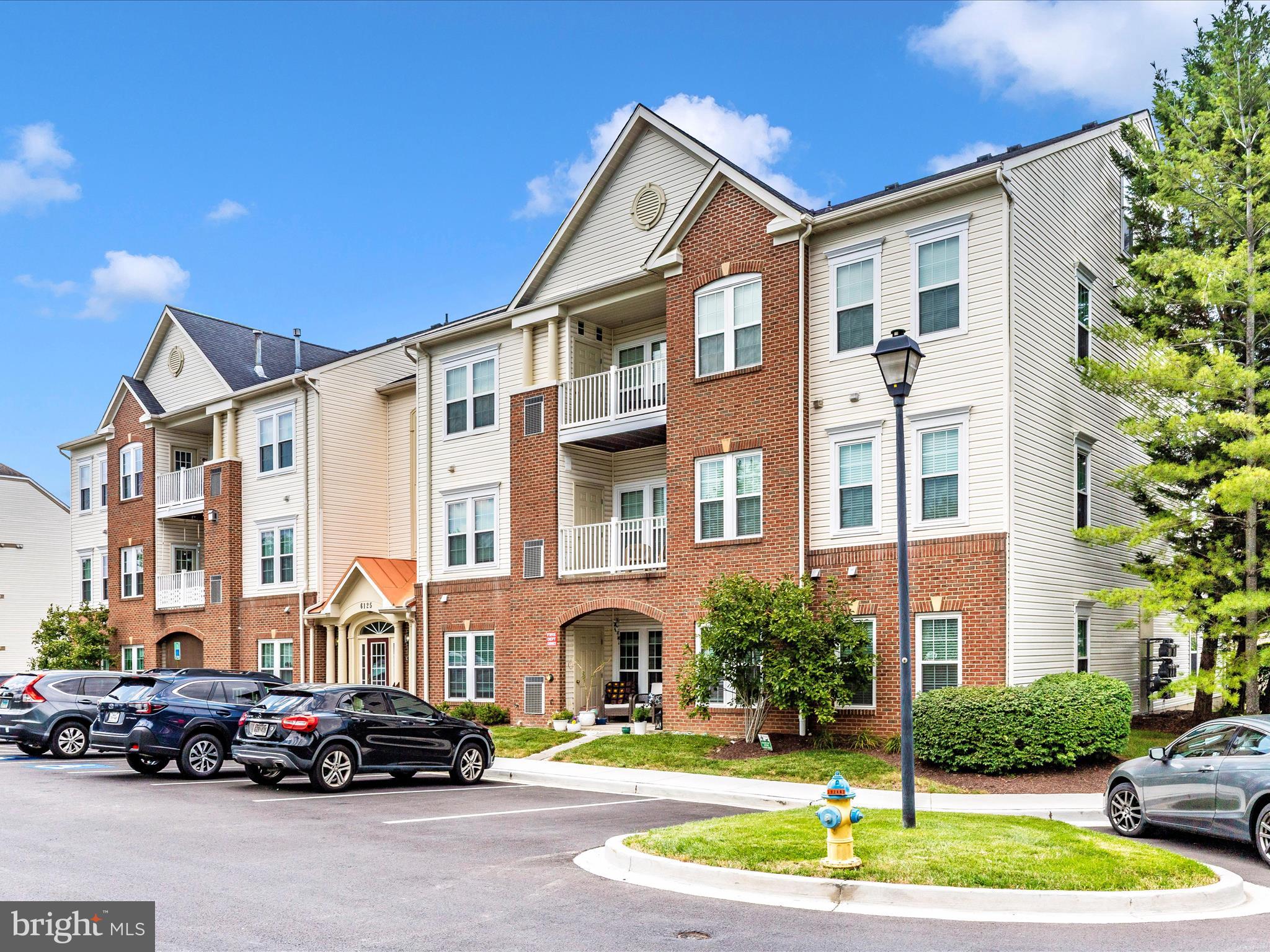 6125 Springwater Place, Unit K Frederick, MD 21701 - Photo 38 of 63 a front view of a residential apartment building with a garden and plants