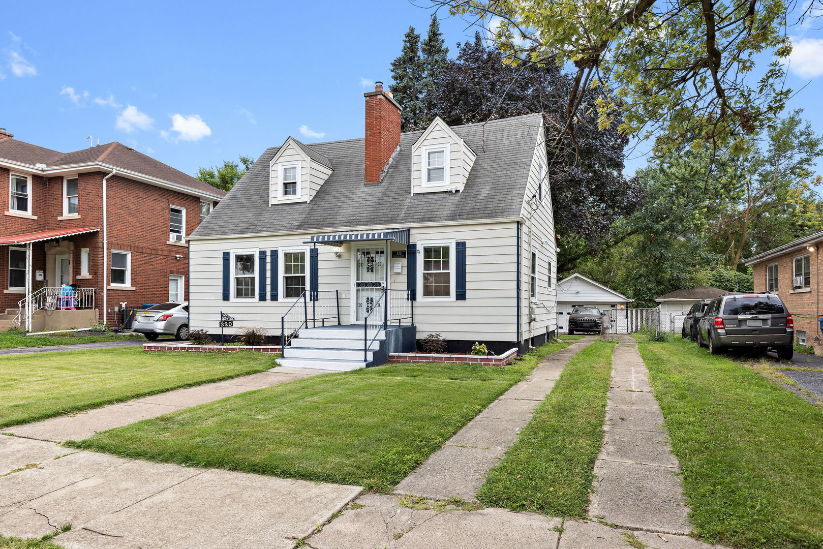 320 Streamside Drive Harvey, IL 60426 - Photo 3 of 26 a front view of a house with a yard table and chairs