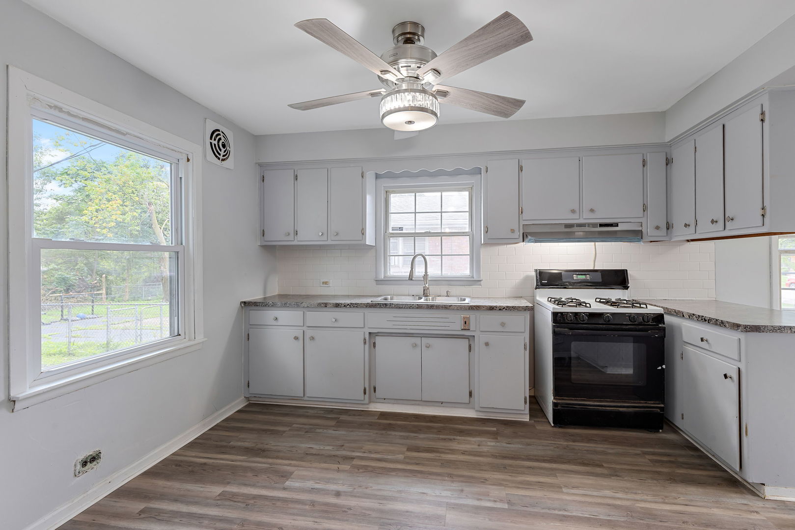 320 Streamside Drive Harvey, IL 60426 - Photo 8 of 26 a kitchen with granite countertop a stove a sink and dishwasher with wooden floors