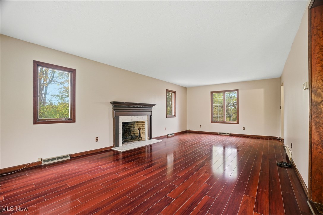 11710 Butternut Road Chardon, OH 44024 - Photo 11 of 48 living room with a premium wood burning fireplace and dark wood-style flooring ( floors are Not scratched - just a shadow)