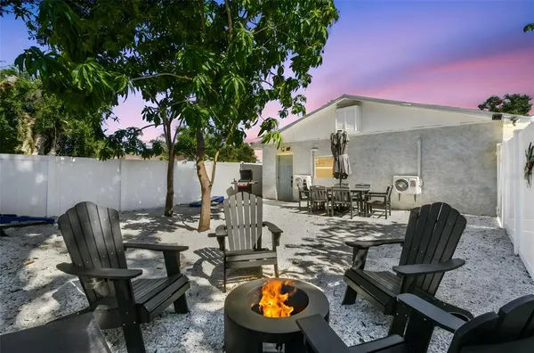 a view of a backyard with furniture and a fire pit