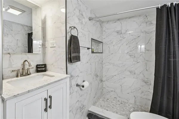 a white toilet sitting next to a shower curtain