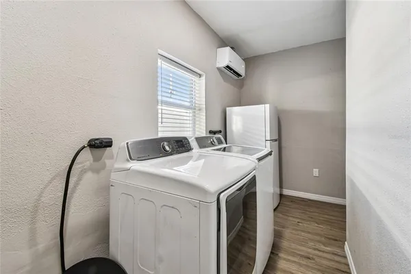 a dining room with stainless steel appliances kitchen island granite countertop furniture and a chandelier