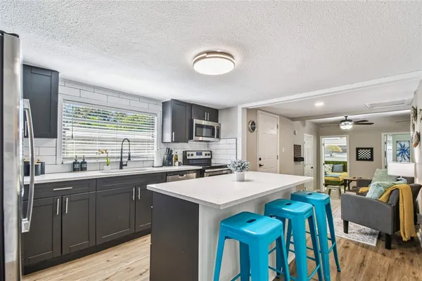 a kitchen with a table chairs sink and cabinets