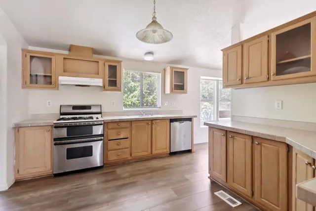 a kitchen with stainless steel appliances granite countertop a stove and a sink