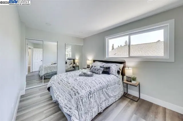 a bedroom with a bed a mirror and a window