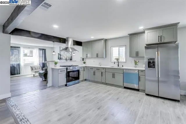 a large kitchen with stainless steel appliances kitchen island a large counter top and a floors