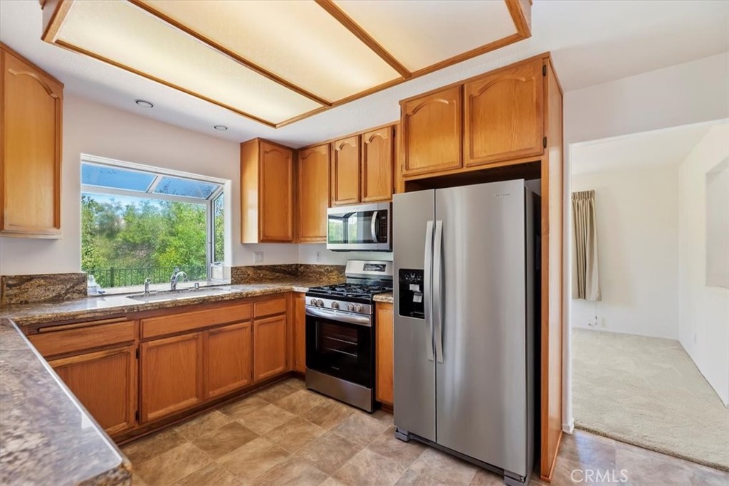 39973 Corte Lorca Murrieta, CA 92562 - Photo 16 of 72 a kitchen with stainless steel appliances granite countertop a refrigerator and a sink