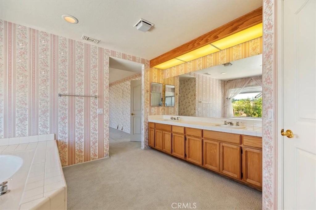 39973 Corte Lorca Murrieta, CA 92562 - Photo 35 of 72 a large bathroom with a double vanity sink and mirror with shower